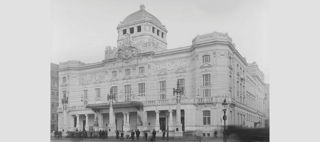 Bild på Dramatens framsida från  1907. Några mörkklädda människor  står nedanför trappstegen upp till entrén.