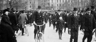Folkmassa i Kungsträdgården. En man på cykel