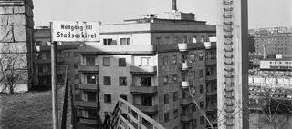 Byggnader och en skylt med texten "Nedgång till Stadsarkivet".