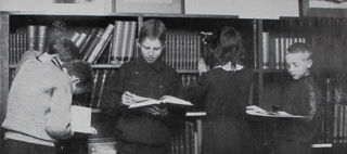 Det är en svartvit bild som föreställer barn som läser i böcker.