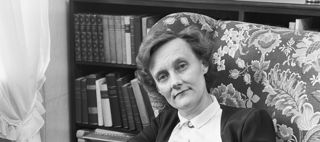 Astrid Lindgren sitter i en blommig fåtölj