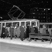 Tegelbacken. Vinterklädda stockholmare kliver på spårvagnen