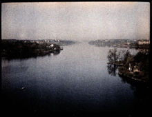Flygbild österifrån över Riddarfjärden och Mälaren. Till höger Sjöpaviljongen vid Smedsudden och till vänster Karlshäll på Långholmen