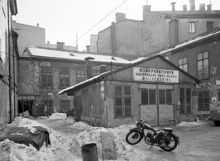 Beridarbansgatan 18, gården österut. Skylt: Bilreparationer, Vagnmakeri, Sadelmakeri, Billackering. I kv. Stigbygeln ligger nu femte höghuset vid Sergels Torg