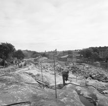 Lundagatans södra sida efter rivningarna. Längst t.v. ligger Lundagatan 6, nuv. Gamla Lundagatan. Sprängning i kv. Haren och Leporiden. Vy österut