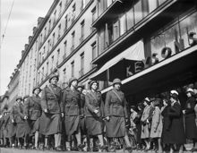 Luftskyddsparad med kvinnor i uniform och hjälmar som marscherar på Sturegatan.