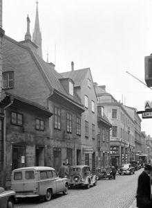 Klarabergsgatan västerut från Drottninggatan. Klarabergsgatan 29-33 med Klara kyrkas torn i fonden. En motorcykel med sidovagn står hitom Klara Östra Kyrkogata