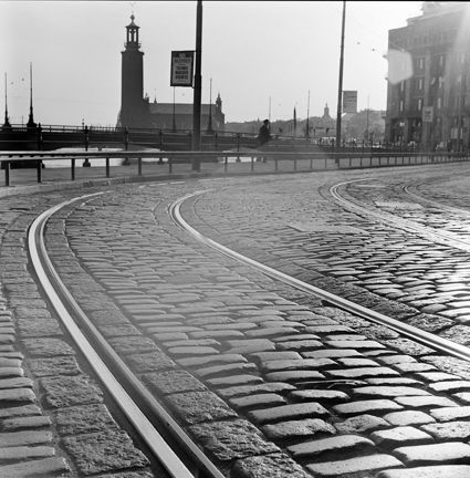 Gatuvy från Strömgatan västerut förbi Rosenbadsparken mot Tegelbacken. I fonden Vasabron och Stadshuset.
