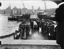 Kistor med kvarlevorna efter Salomon August Andrée, Nils Strindberg och Knut Fraenkel från Andréexpeditionen förs i land på Skeppsholmen från HS Svensksund.