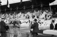 Olympiska spelen i Stockholm 1912. Prisutdelning förbereds och vaktmästare bär fram en tung skulpturbyst av Karl XII i brons, det stora priset från Kung Gustaf V.