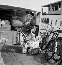 Strömkajen. Sommarflyttande stockholmare lämnar staden och åker ut till skärgården. En mamma gör sig och sitt barn redo för att gå på skärgårdsbåten