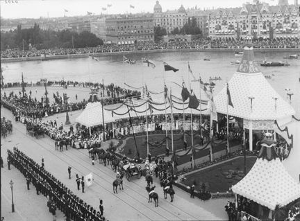 Paviljonger, utsmyckningar, flaggor och många åskådare.