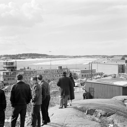 Svartvitt foto, män blickar ut över nejden, frusen sjö i fonden