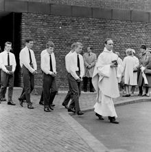 Präst och manliga konfirmander tågar ut från Farsta kyrka
