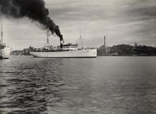 Fartyget ""Örnen"" stävar över Riddarfjärden. Det ryker tungt och svart ur skorstenen.