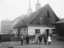 Fatburen. Gård på Värmdögatan 51, (senare Malmgårdsvägen). Barn står uppställda i förgrunden.