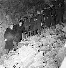 Sprängningar för tunnelbanebygget 20 meter under jord, korsningen S:t Eriksgatan-Kungsholmsgatan. En grupp människor i bergsrummet