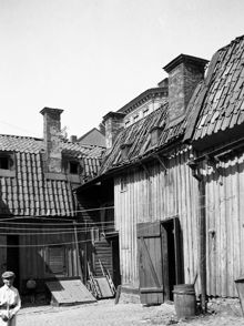Gårdssidan vid Timmermansgatan 35. En pojke ler mot fotografen