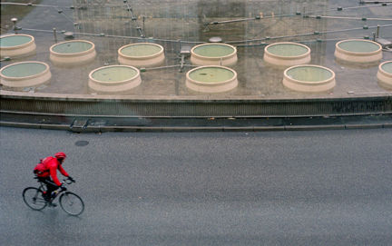 Cyklist och fontän sedda snett från ovan.