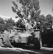 Barn sitter på pansarvagn i samband med utställning av pansarvagnar