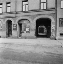 Parti av gatufasad till huset Ringvägen 134, bottenvåning med körport. Inför rivning