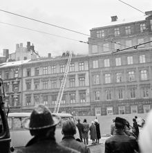 Människor som betraktar släckningsarbete på taket till Arvid Nordquist HAB, Biblioteksgatan 27