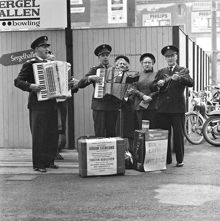 En grupp från Frälsningsarmén sjunger samt spelar dragspel och mandolin på gatan