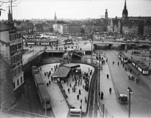 Tunnelbanestation vid Slussen år 1934, med utsikt över Södermalmstorg med spårvagnar. Gamla Stan i bakgrunden.