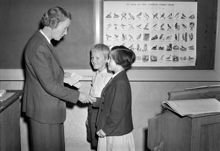 Valhallavägen 76, Engelbrekts folkskola. Skolstart. Elever hälsar på fröken framme vid svarta tavlan