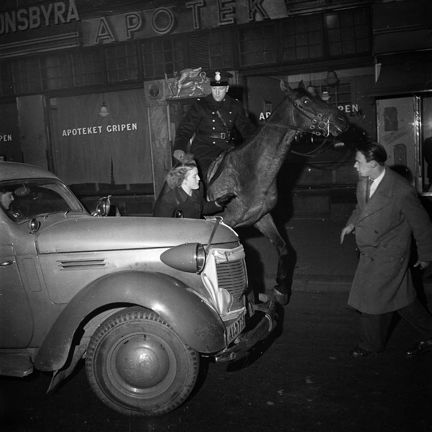 En ridande polis, en kvinna och en man på gatan, en lastbil.