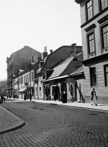 Sankt Paulsgatan västerut från Bellmansgatan. Sankt Paulsgatan 20-24 med skyltar på butiksfasaderna