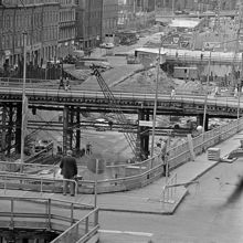 Från Vattugatan vid Brunkebergstorg västerut över rivna kv. Elefanten. Tv. Herkulesgatan och kv. Björnen. Drottninggatan går på en provisorisk bro
