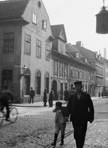 Regeringsgatan 54 A, B och C söderut från hörnet av Lästmakargatan. I folklivet står en polis med kask och sabel