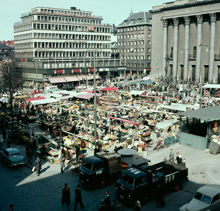 Hötorget mot varuhuset Tempo, Kungsgatan och Konserthuset. PUBs lastbilar i förgrunden