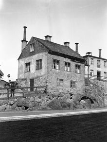 En man passerar Brännkyrkagatan 132. Nuvarande Hornsbruksgatan 26. En fågelholk t.v. i fonden