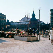 Östermalms saluhall sedd från Östermalmstorg. Försäljning av mat och blommor på torget