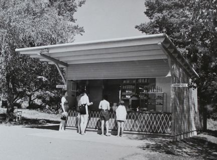 Tre vuxna och två barn handlar i en kiosk