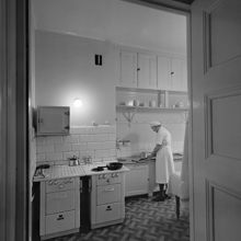 Köksinteriör. En kvinna rensar fisk