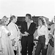 Balkong på Grand Hotel med utsikt mot Slottet. Kirk Douglas med aspiranter till en roll i filmen ""The Vikings"". Fr.v. Evy Thelander, Cecile Brestler och Tutta Paulson