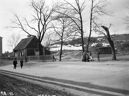 Brännkyrkagatan västerut från Långholmsgatan. Träbyggnaden till vänster i bild  har adress Brännkyrkagatan 136-148 och revs 1911. Gatan heter nu Bergsunds Strand. På berget i fonden mot norr ligger idag Högalidsskolan (byggd 1922).