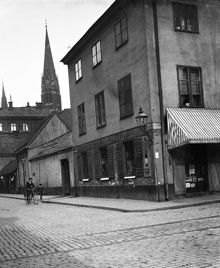 Kammakargatan österut från Stora Bastugatan (nu Sveavägen) med Johannes kyrka i fonden. T.h. Kammakargatan 11, kv. Moraset. En pojke cyklar