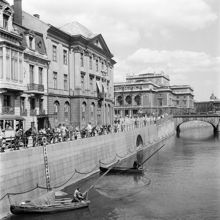 Norrström och Strömgatan 16-18, vy från Riksbron. Fiskebåtar, håvbåtar, och åskådare. Operahuset i fonden