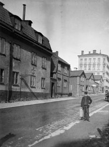 En pojke står på Timmermansgatan norrut från Fatbursgatan. T.v. Timmermansgatan 48-42. Mellan Timmermansgatan 46 och 44 går Bengt Ekehjelmsgatan. Flerbostadshuset ligger vid Högbergsgatan 70