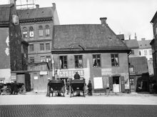 Butiker och verkstäder vid Oxtorget 2 på Oxtorgets norra sida. Husen i fonden ligger vid Lutternsgatan (nu Kungsgatan). Här ligger idag Södra Kungstornet vid nuvarande Oxtorget 8