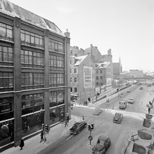 Exteriör av Hamngatspalatset vid hörnet av Regeringsgatan. 
Kv. Åskslaget och kv. Trollhättan står inför rivning (nuvarande Gallerians plats). I fonden Malmskillnadsgatans bro över Hamngatan.