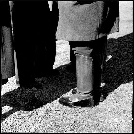 Närbild på en persons stövlar och nedre delen av rocken.