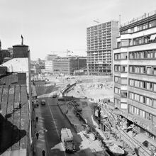 Hamngatan västerut mot blivande Sergels Torg. Rivet är Hamngatan 24-28 före korsningen med Malmskillnadsgatan.  5:e höghuset är under byggnation. T.v. kv. Trollhättan