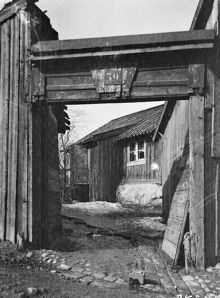 Blekingegatan 39, senare Blekingegatan 31. Vy genom portöppning i planket mot ett trähus på gården