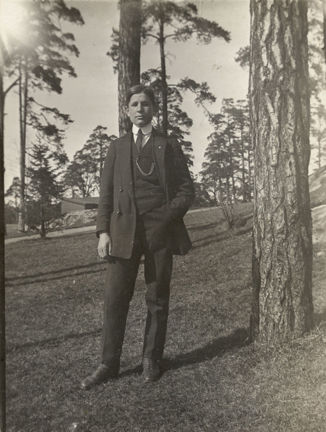 Foto på Mulle Österkvist i kostym stående i en tallbacke.