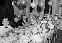 Hagagatan 52, hemma hos familjen Linck. Julgransplundring, barnen samlade kring bordet